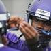 Pioneer High School player helps a teammate with his helmet during a break in the action on the first day of practice on Monday, August 12, 2013. Melanie Maxwell | AnnArbor.com